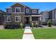 Inviting two-story home with stone accents, a covered porch, landscaped yard, and a well-manicured lawn at 11933 Norfolk Ct, Commerce City, CO 80022
