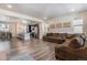 Open-concept living room and kitchen with hardwood floors, ample seating, and stainless steel appliances at 11933 Norfolk Ct, Commerce City, CO 80022