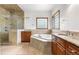Bathroom featuring dual sinks, bathtub and a glass-enclosed shower at 1195 W 70Th Ave, Denver, CO 80221