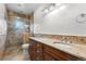 Bathroom with a double vanity with granite counters and glass shower with tile surround at 1195 W 70Th Ave, Denver, CO 80221