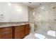 Well-lit bathroom with a glass-enclosed shower, granite countertop, and wooden cabinets at 1195 W 70Th Ave, Denver, CO 80221