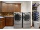 Laundry area with modern washer and dryer, paired with cabinetry and storage shelves at 1195 W 70Th Ave, Denver, CO 80221