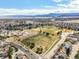 Wide aerial view showcasing the neighborhood, nearby school, playground, and a vast green space at 8815 W Quarto Cir, Littleton, CO 80128