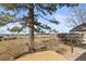 Spacious backyard featuring mature trees, a swing set, and privacy fence at 8815 W Quarto Cir, Littleton, CO 80128