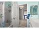 A bright aqua bathroom showcases a shower with a grab bar, a vanity, and cheerful decor at 8815 W Quarto Cir, Littleton, CO 80128