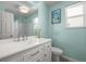 This bright bathroom features a white vanity with marble countertop and an abundance of natural light at 8815 W Quarto Cir, Littleton, CO 80128