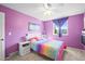 Vibrant purple bedroom with rainbow decor and a cozy, colorful bed by the window at 8815 W Quarto Cir, Littleton, CO 80128