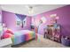 A colorful bedroom features bright purple walls, rainbow accents, and cheerful decor at 8815 W Quarto Cir, Littleton, CO 80128