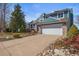 Charming two-story home with brick accents, a large driveway, and landscaped front yard at 8815 W Quarto Cir, Littleton, CO 80128