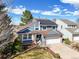Charming blue two-story home featuring a well-manicured lawn and a two-car garage at 8815 W Quarto Cir, Littleton, CO 80128