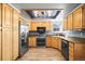 Well-lit kitchen features stainless steel appliances, light wood cabinets, and stylish light fixture at 8815 W Quarto Cir, Littleton, CO 80128
