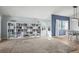 Open-concept living room with large bookshelves, natural light, and hardwood floors at 8815 W Quarto Cir, Littleton, CO 80128