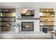 Inviting living room featuring a cozy fireplace and custom wood shelving at 8815 W Quarto Cir, Littleton, CO 80128