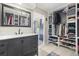 A spacious walk-in closet features custom shelving, a vanity area, and a stylish gray vanity with a marble countertop at 8815 W Quarto Cir, Littleton, CO 80128