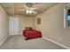 Bedroom showcasing a red comforter, ceiling fan, and neutral carpet at 1166 Belgian Trl, Elizabeth, CO 80107