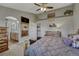 Comfortable main bedroom featuring a decorative ceiling fan, wood furnishings, and ensuite bathroom at 1166 Belgian Trl, Elizabeth, CO 80107
