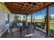 Covered brick patio with a table, chairs, and swing set for outdoor dining and relaxation at 1166 Belgian Trl, Elizabeth, CO 80107