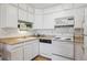 Well-lit kitchen with white cabinetry, neutral countertops, and essential appliances at 655 S Alton Way # 5C, Denver, CO 80247