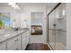 Well-lit bathroom with double vanity, granite countertops, shower, and bedroom views at 10200 Xanadu St, Commerce City, CO 80022