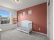 Bedroom featuring a white crib, gray carpet, and a bright window at 10200 Xanadu St, Commerce City, CO 80022
