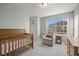 Bedroom featuring a wood crib, gray carpet, and lots of natural light at 10200 Xanadu St, Commerce City, CO 80022