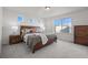 Bright bedroom with natural light, neutral colors, and a wooden dresser at 10200 Xanadu St, Commerce City, CO 80022