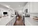 Bright kitchen with white cabinetry, stainless steel appliances, and hardwood floors at 10200 Xanadu St, Commerce City, CO 80022