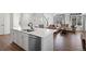Modern kitchen with white cabinets, stainless appliances, and an open concept to the living room at 10200 Xanadu St, Commerce City, CO 80022