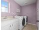 Convenient laundry room featuring modern washer and dryer, white cabinets, and a sink at 10200 Xanadu St, Commerce City, CO 80022