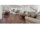 Bright living room with hardwood floors, modern furniture, and open concept to the kitchen at 10200 Xanadu St, Commerce City, CO 80022