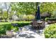 Large backyard with mature trees, patio dining set, and fire pit seating area at 4483 W Cottonwood Pl, Littleton, CO 80123