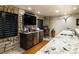 Basement wet bar featuring stone accent wall, stainless steel refrigerator, and marble countertop at 4483 W Cottonwood Pl, Littleton, CO 80123