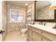 Charming powder room with patterned wallpaper, a decorative mirror, and a custom vanity at 4483 W Cottonwood Pl, Littleton, CO 80123