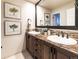 Bathroom features a double vanity, granite countertop, framed artwork, and warm lighting at 4483 W Cottonwood Pl, Littleton, CO 80123