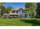 Beautiful two-story home with lush lawn, mature trees, and inviting blue front door at 4483 W Cottonwood Pl, Littleton, CO 80123