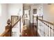 Beautiful hallway with hardwood floors, white wood banisters and decorative artwork on the walls at 4483 W Cottonwood Pl, Littleton, CO 80123