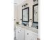 Modern bathroom features double sinks, black fixtures, and stylish mirrors at 3600 S Pierce St # 7-201, Denver, CO 80235