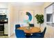 Bright dining room featuring a wooden table and four blue chairs at 3600 S Pierce St # 7-201, Denver, CO 80235