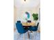Bright dining room features a round table and four blue chairs at 3600 S Pierce St # 7-201, Denver, CO 80235