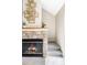 Cozy stone fireplace with glass doors leading to a carpeted staircase at 3600 S Pierce St # 7-201, Denver, CO 80235