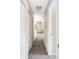 Hallway featuring neutral carpet and paint, white doors, and a view into the entry and living spaces at 3600 S Pierce St # 7-201, Denver, CO 80235