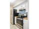 Galley kitchen featuring stainless steel appliances, butcher block countertops and white cabinetry at 3600 S Pierce St # 7-201, Denver, CO 80235