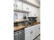 Contemporary kitchen features butcher block countertops, white cabinets, and stainless dishwasher at 3600 S Pierce St # 7-201, Denver, CO 80235