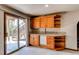 Finished basement with custom bar featuring cabinetry, a mini-fridge, open shelving and sliding doors to the backyard at 9754 Las Colinas Dr, Lone Tree, CO 80124