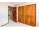 Neutral carpeted bedroom with wood-paneled doors and closet at 9754 Las Colinas Dr, Lone Tree, CO 80124