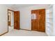 Carpeted bedroom with open wood-paneled door and closet at 9754 Las Colinas Dr, Lone Tree, CO 80124
