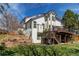 Two-story home with a large deck, brick accents, lush landscaping, and a multi-level yard at 9754 Las Colinas Dr, Lone Tree, CO 80124