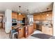 Kitchen features stainless steel appliances, wood cabinetry and large center island with barstool seating and granite countertops at 9754 Las Colinas Dr, Lone Tree, CO 80124