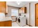 Bright laundry room with white appliances, tile floor, cabinets and window for natural light at 9754 Las Colinas Dr, Lone Tree, CO 80124