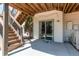 Covered patio with sliding glass door, stairs to the upper deck, and a concrete surface at 9754 Las Colinas Dr, Lone Tree, CO 80124
